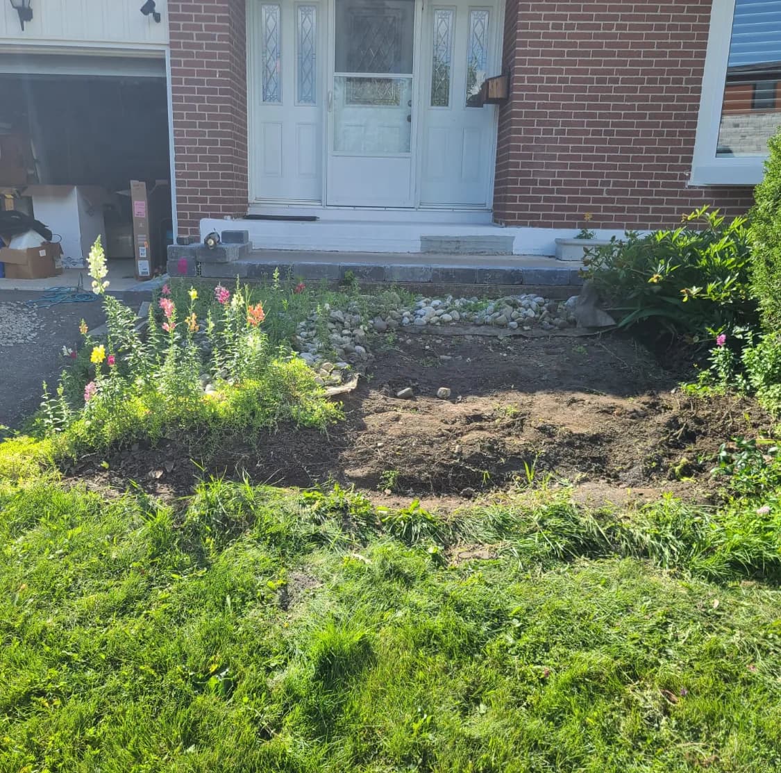 Front of house before hardscaping with an overgrown garden bed and a plain concrete step