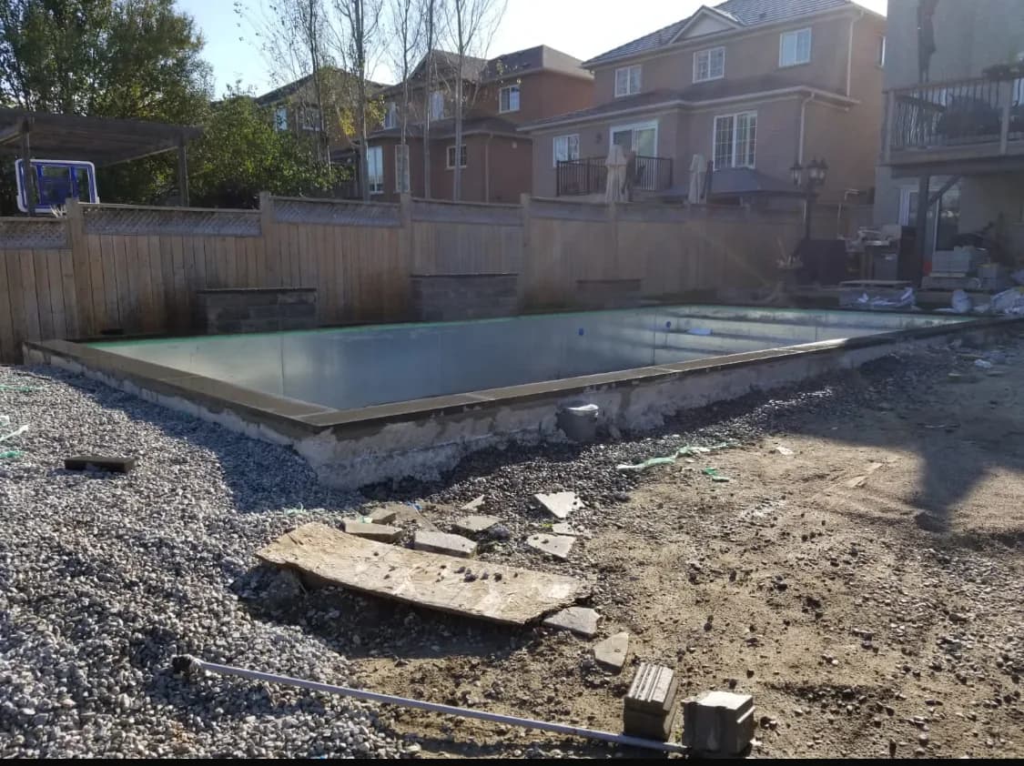 Pool before hardscaping with a bare shell, gravel base, and open grade around the perimeter