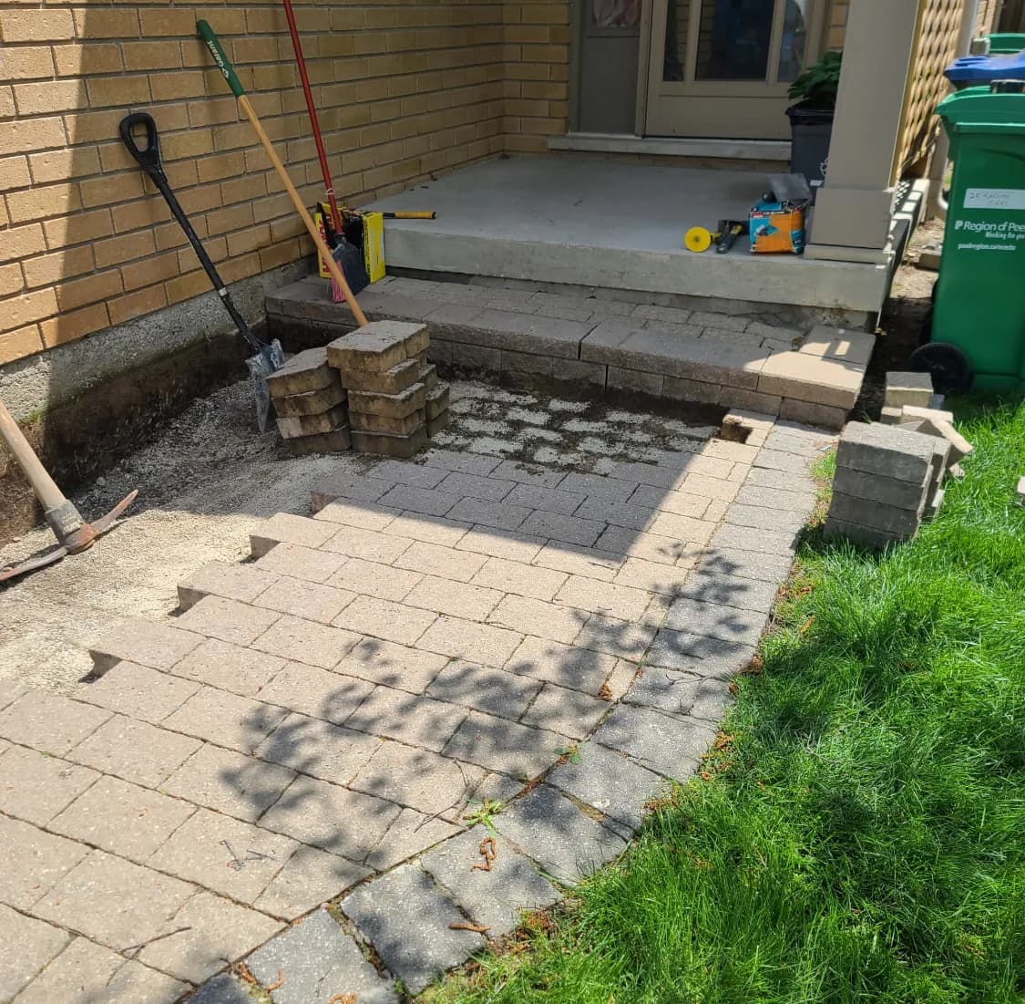 Side yard walkway before hardscaping with old faded pavers removed and base exposed